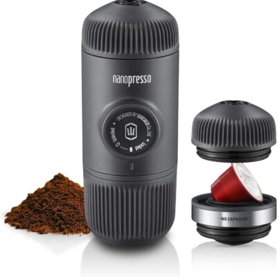 Black Wacaco Nanopresso portable coffee maker with a compact, ribbed design, shown alongside ground coffee and a compatible Nespresso capsule adapter. Ideal for travel, it brews espresso on the go without electricity, using manual pressure.